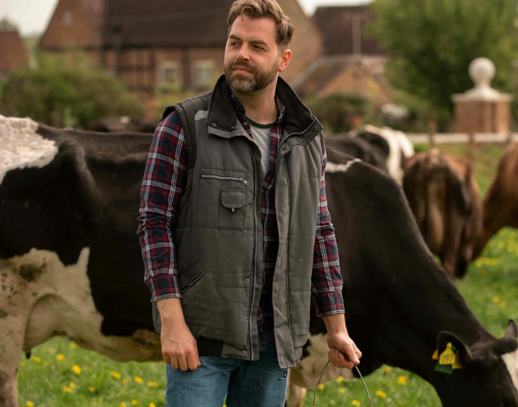 Homme dans son avec avec ses vaches laitières